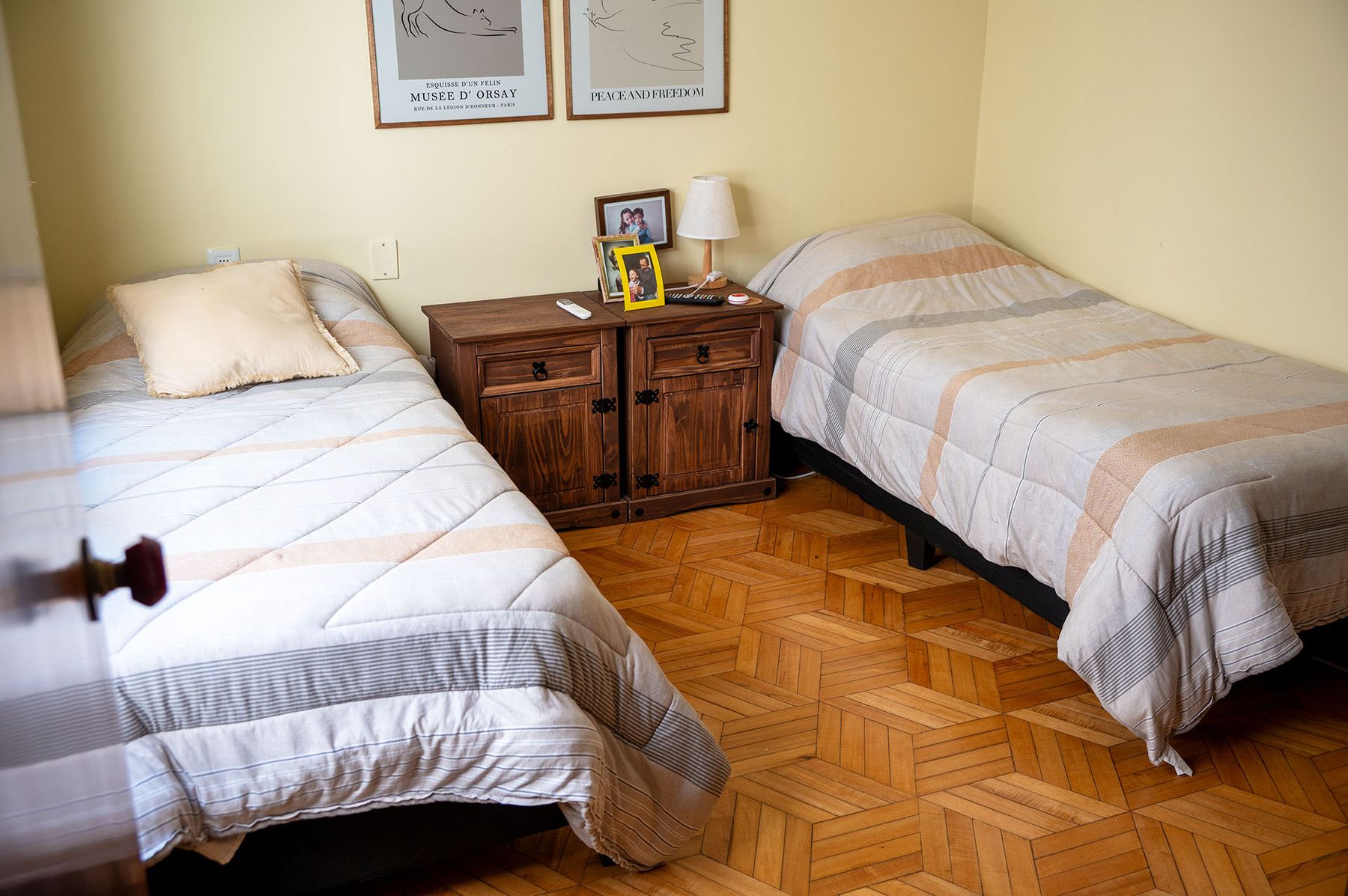 Habitación doble con dos camas y mesa de luz de madera