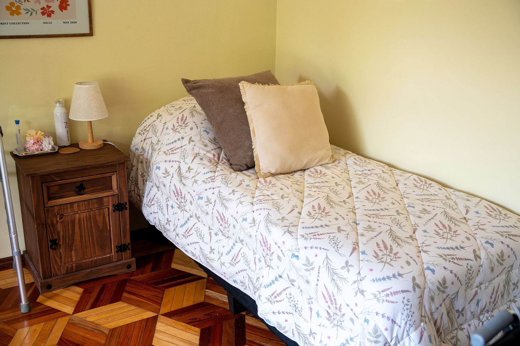 Habitación con cama individual y acolchado floral