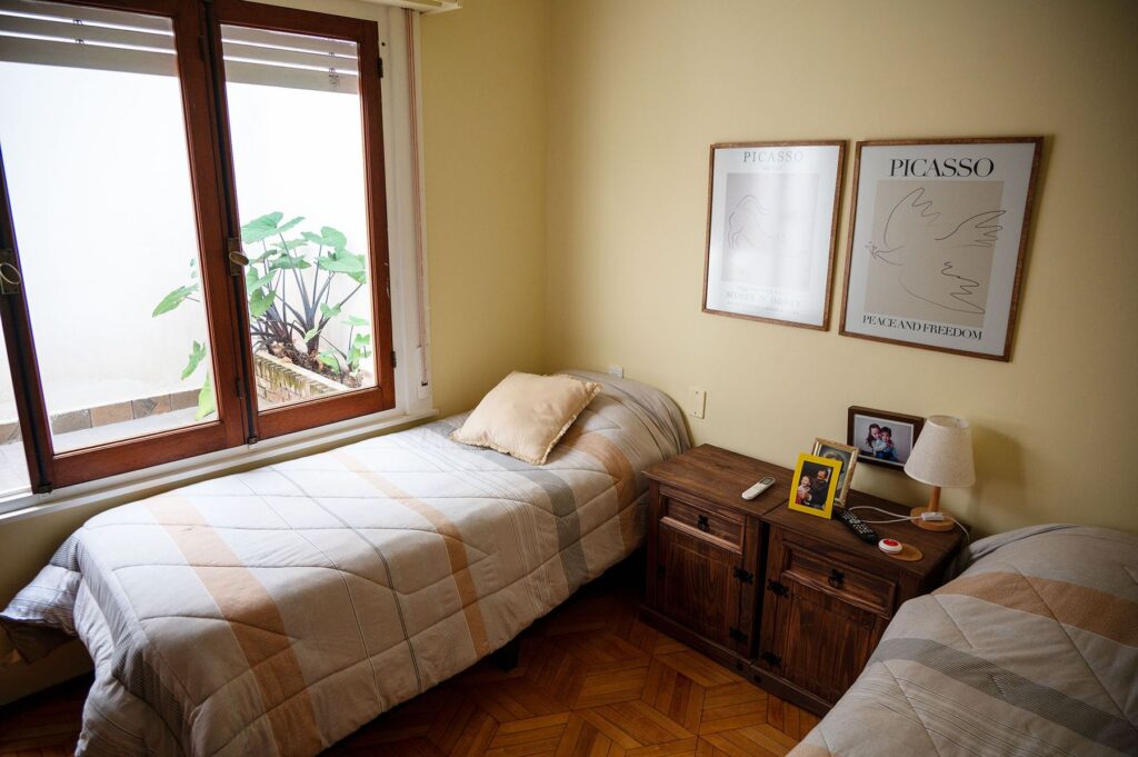 Habitación luminosa con ventana, cama individual y cuadros