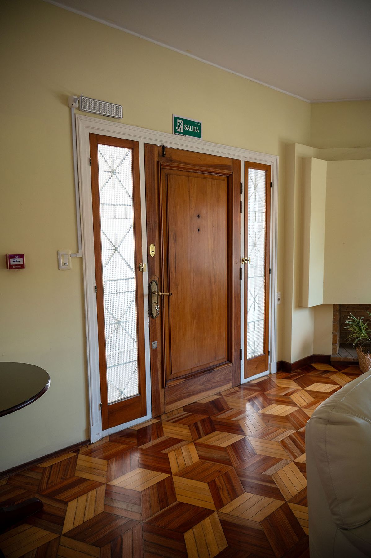 Puerta de entrada de madera con vitrales laterales