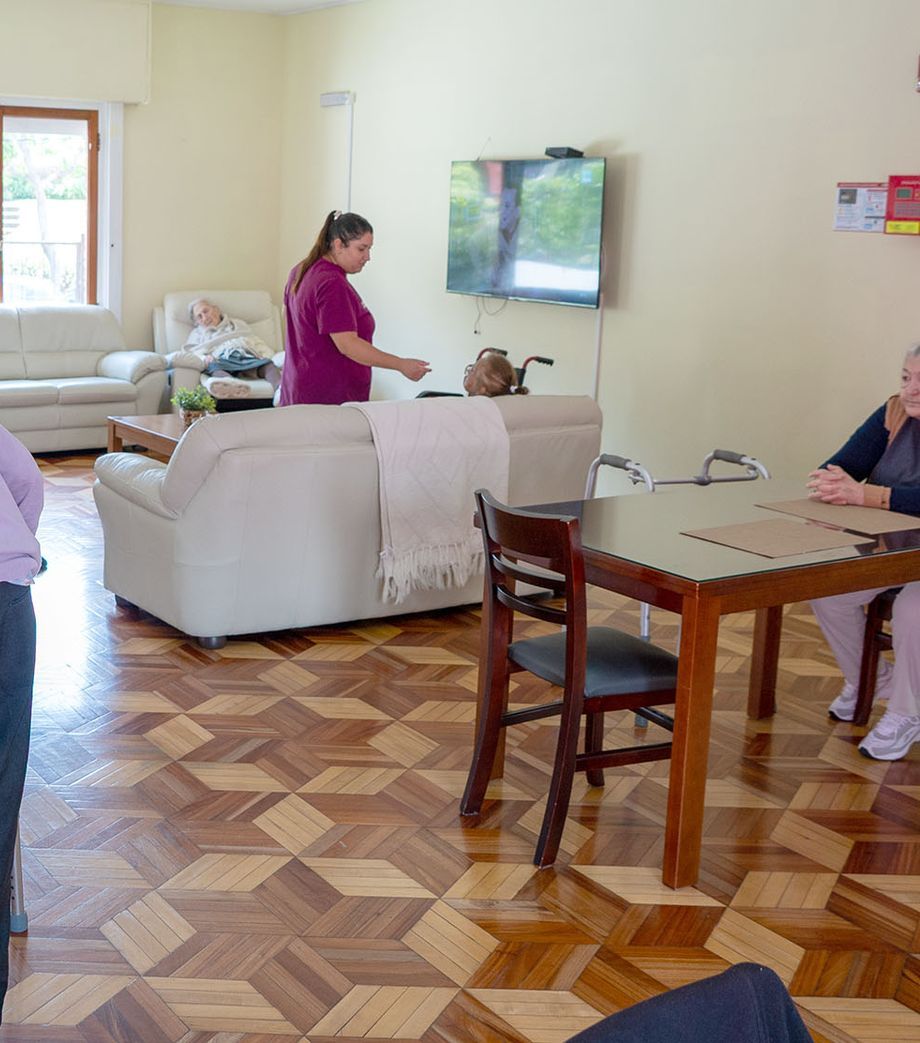 Residentes en la sala comedor junto a una cuidadora