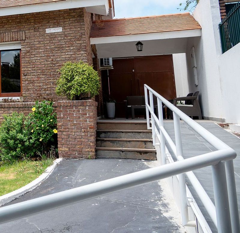 Rampa de acceso con baranda en la entrada de la casa